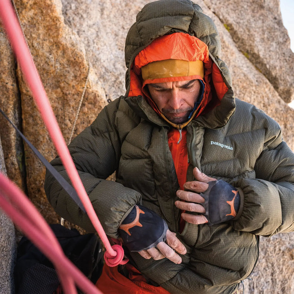 Person in climbing gear sitting on a rock, wearing a Patagonia jacket.