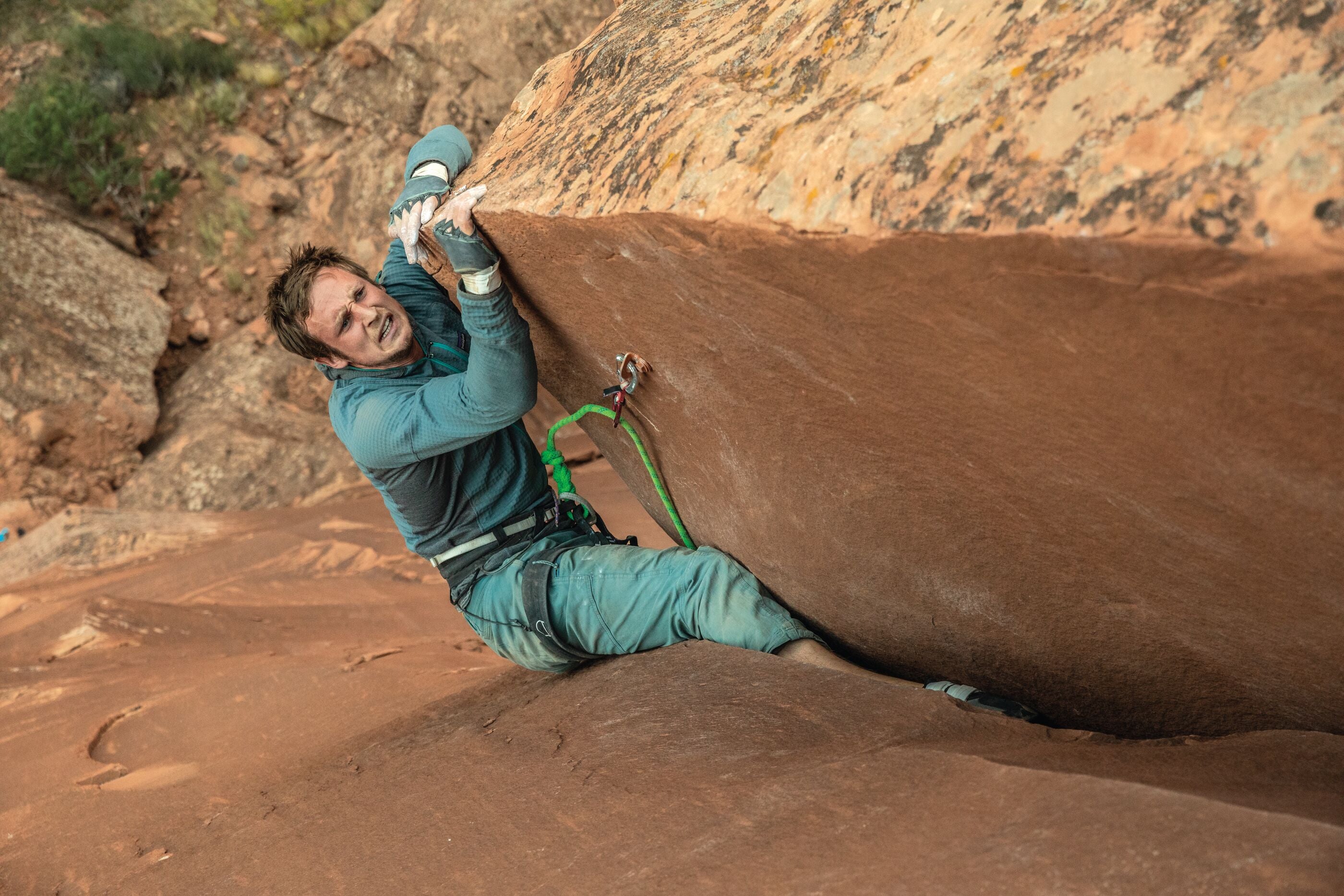 Person climbing a large rock formation in a natural outdoor setting